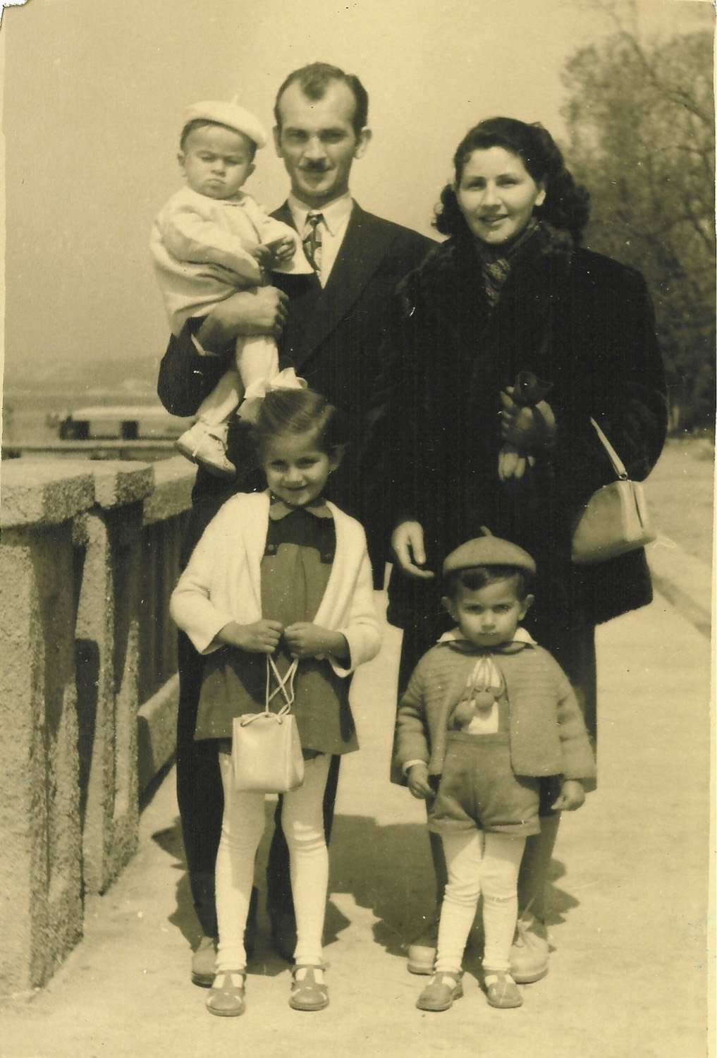 A family of five on a seafront balustrade, early 1950s