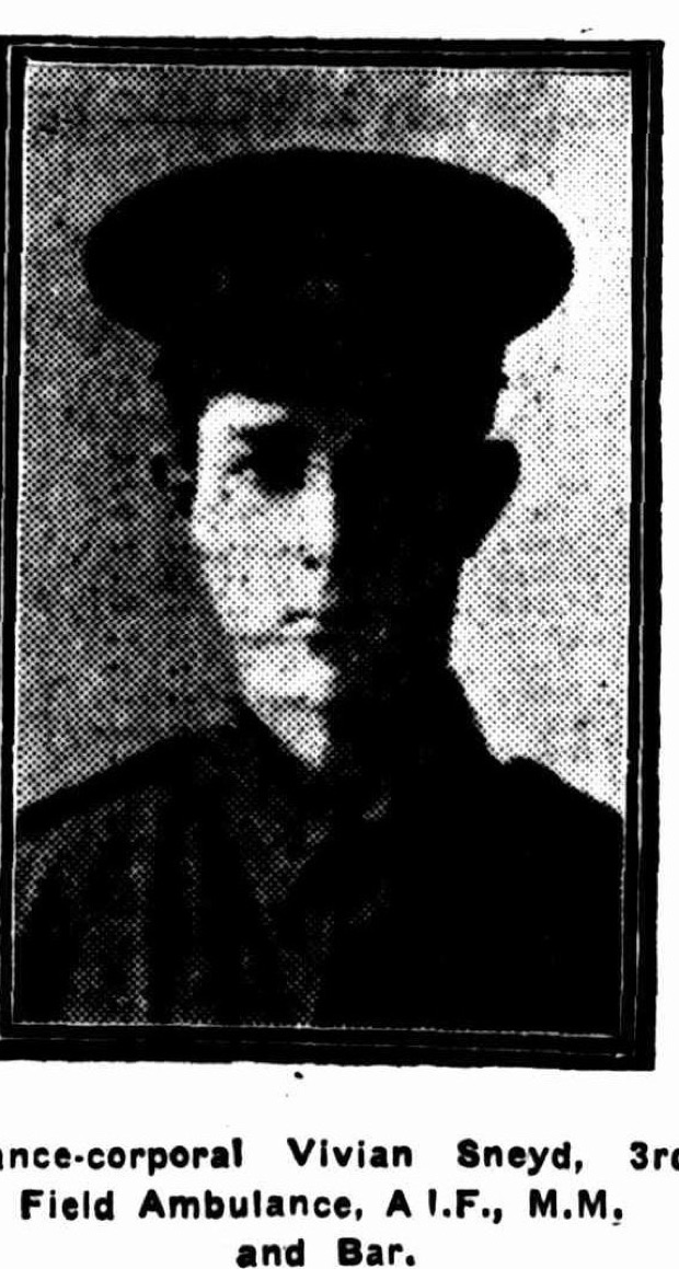Newspaper halftone portrait of a young man in a peaked military cap and tunic, head and shoulders, looking slightly to his left.