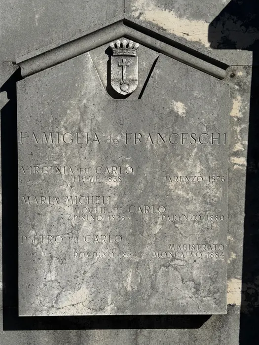 The memorial to Carlo, under a shield